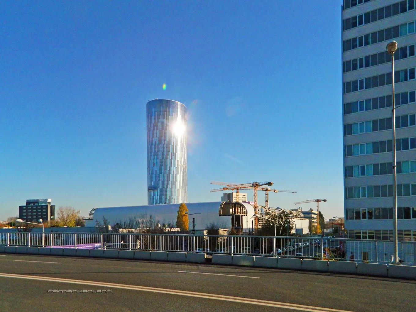 Turnul de sticlă Floreasca SkyTower și clădiri de birouri din apropiere, în București, sub un cer senin.
