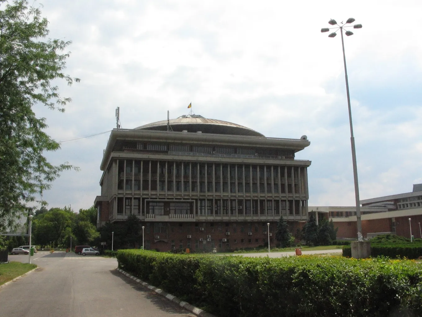 Clădirea cu cupolă a Rectoratului Universității Politehnica din București, văzută de pe aleea de acces într-o zi de vară.