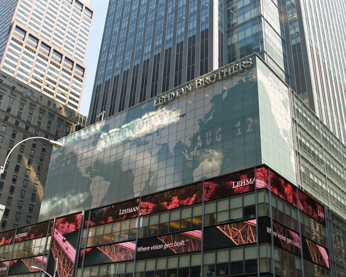 Turnul sediului Lehman Brothers din Manhattan, cu etajele de jos acoperite de o hartă a lumii și de ecrane video.