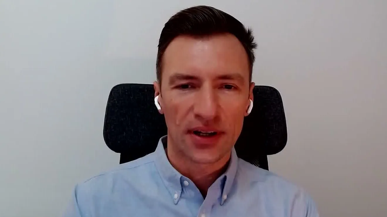 Marius Hanganu într-o convorbire video, în episodul ZF IT Generation, în cămașă albastru-deschis, în fața unui scaun de birou negru.